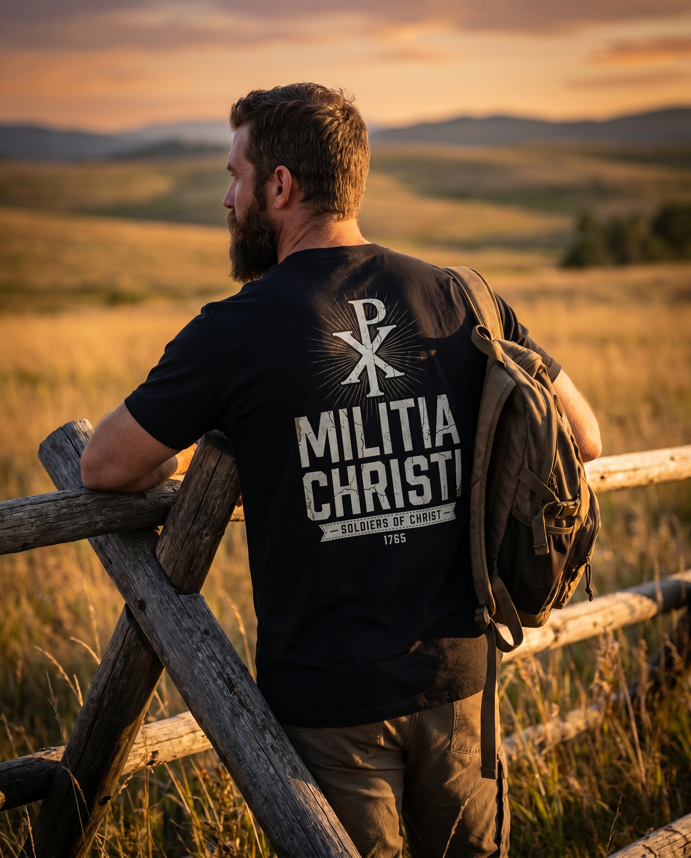 1765 Apparel — Militia Christi Chi-Rho tee in Black, worn at a golden-hour split-rail fence