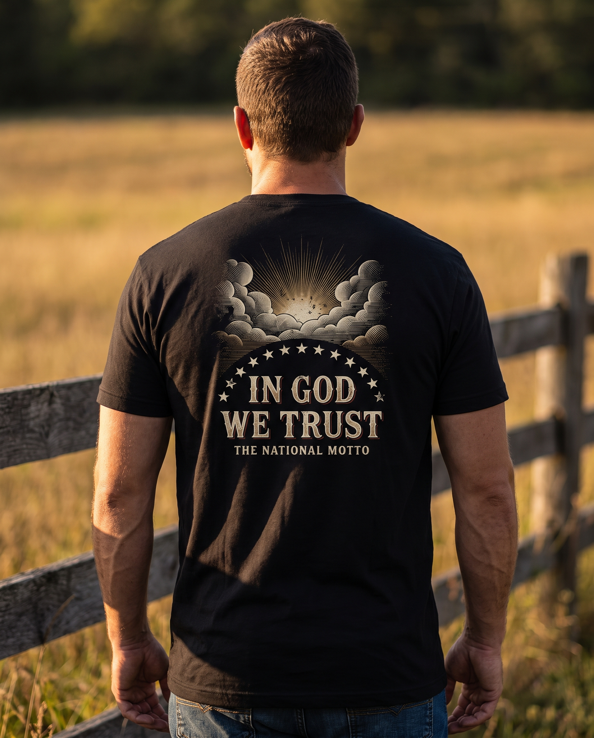 Man seen from behind wearing the In God We Trust shirt: sunburst through engraved clouds, an arc of stars, bold motto