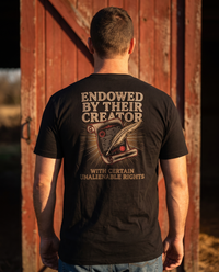 Man seen from behind wearing the tee: ENDOWED BY THEIR CREATOR over an engraved parchment and quill in gold rays &mdash; view 1