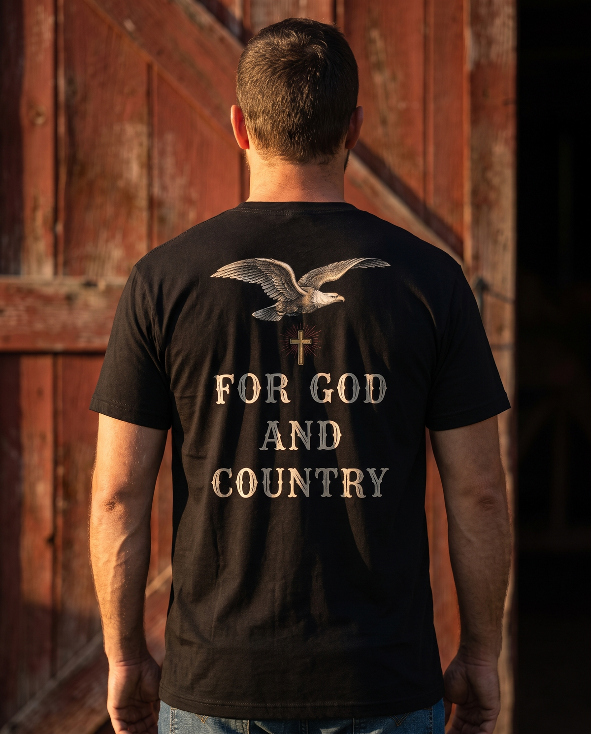 Man seen from behind wearing the tee: engraved eagle and small radiant cross over FOR GOD AND COUNTRY