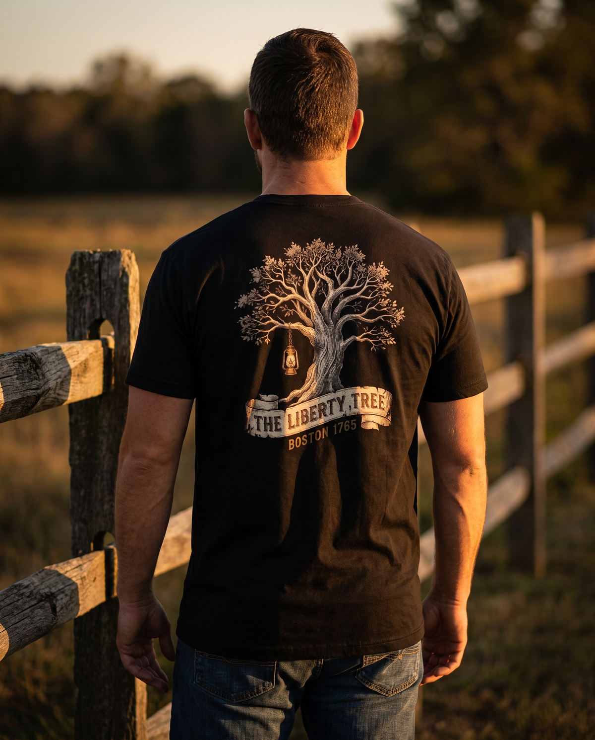 Man seen from behind wearing the Liberty Tree shirt: engraved elm with a hanging lantern over a Boston 1765 banner