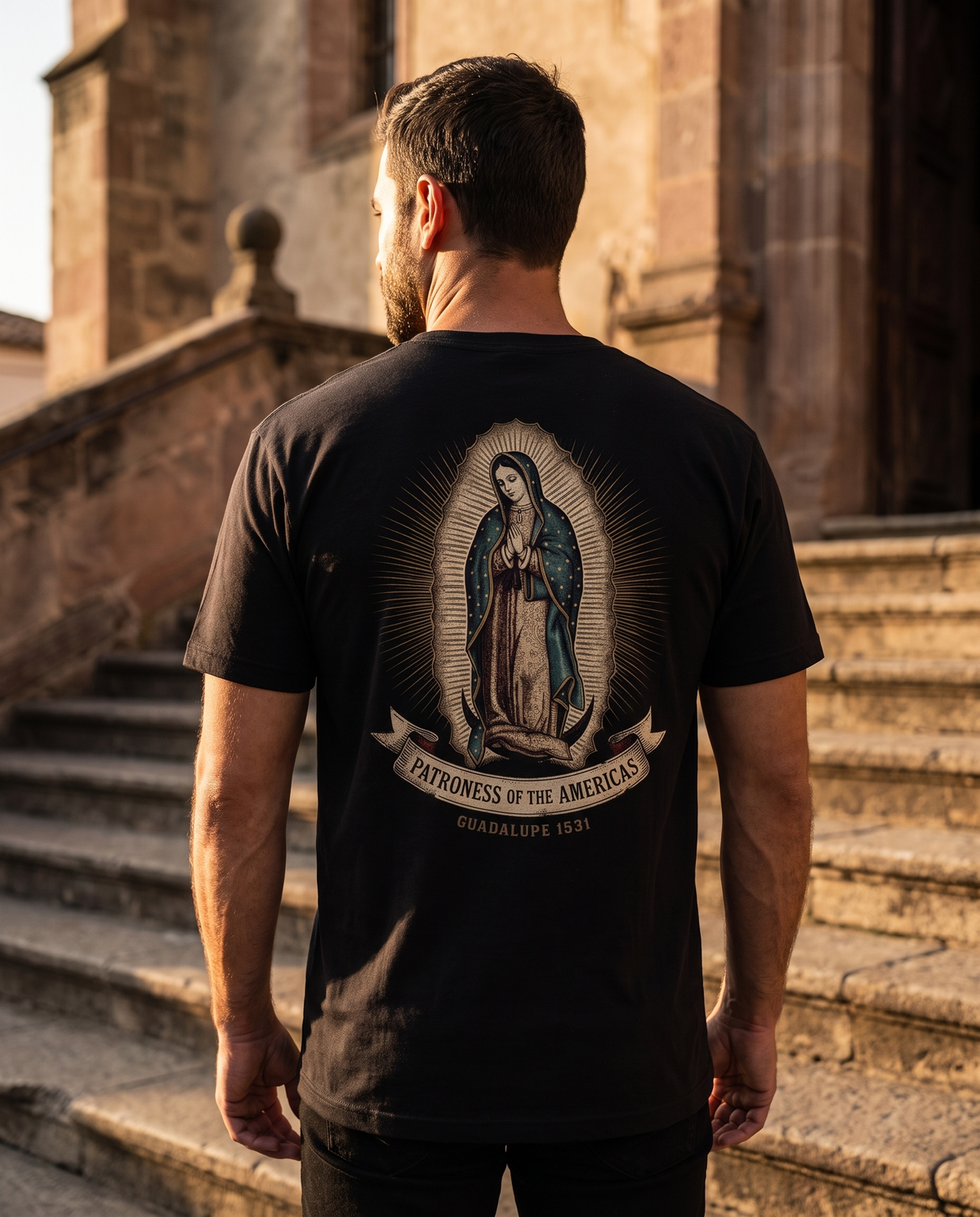 Man seen from behind wearing the Guadalupe shirt: Our Lady in a star-strewn mantle amid rays, Patroness of the Americas