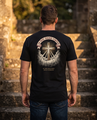 Man seen from behind wearing the In Hoc Signo Vinces shirt: radiant gold cross over clouds, Latin banner and English line &mdash; view 1