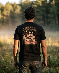 Man seen from behind wearing the tee: an engraved warship in cannon smoke under 'I Have Not Yet Begun to Fight' &mdash; view 1