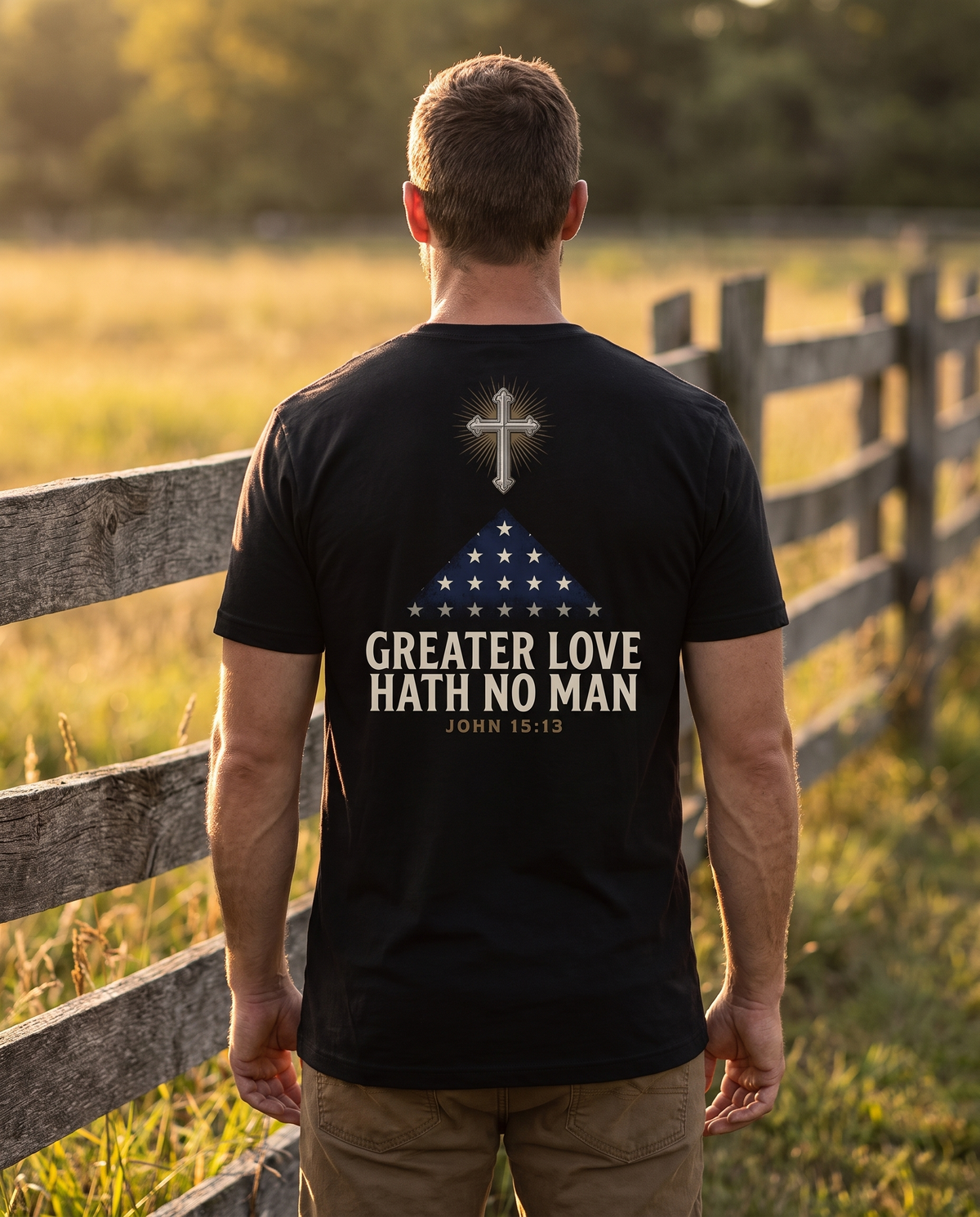 Man seen from behind wearing the tee: radiant cross above a folded memorial flag over GREATER LOVE HATH NO MAN, John 15:13