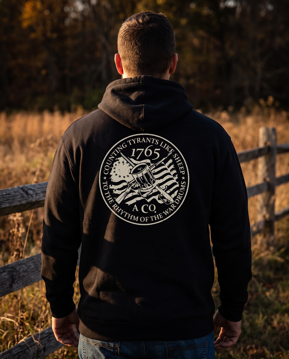 Counting Tyrants Like Sheep USA-made hoodie, back print, worn by a man at a split-rail fence
